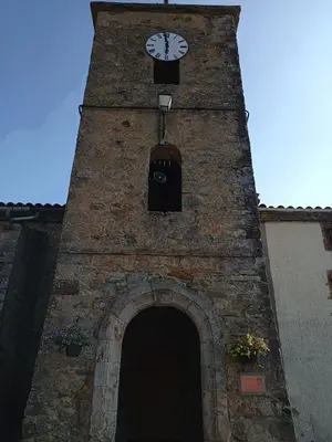 a tall brick tower with a clock on it at maison dans village rural in Saint-Louis-et-Parahou