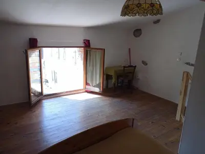 an empty room with a large window and a table at maison dans village rural in Saint-Louis-et-Parahou
