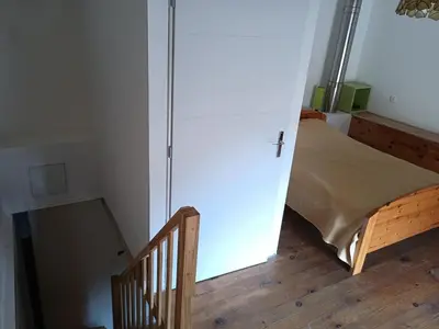 a room with a door and a bed and a staircase at maison dans village rural in Saint-Louis-et-Parahou