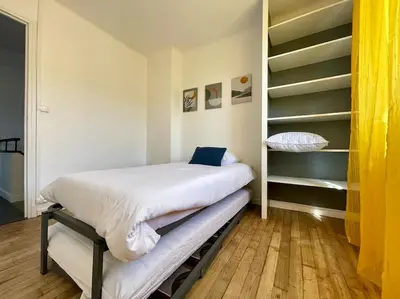 a small bedroom with a bed and shelves at Maison Les Bruyères - 3 chambres - jardin et parking à Carcassonne in Carcassonne
