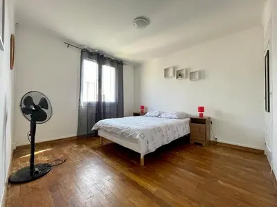 a bedroom with a bed and a fan in it at Maison Les Bruyères - 3 chambres - jardin et parking à Carcassonne in Carcassonne