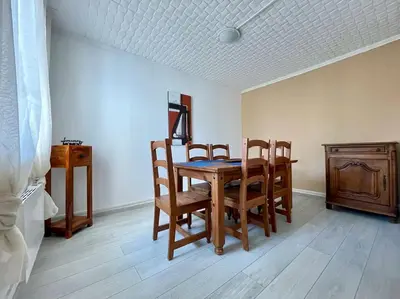 a dining room with a wooden table and chairs at Maison Les Bruyères - 3 chambres - jardin et parking à Carcassonne in Carcassonne