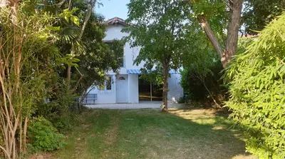 a white house with trees in front of it at LA PETITE BICOQUE au fond du jardin in Quillan