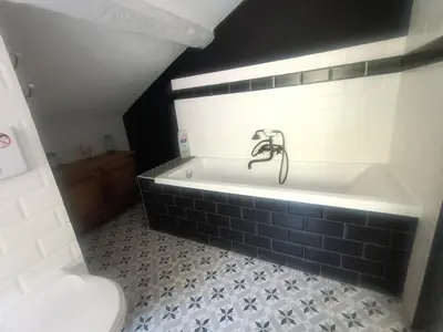 a bathroom with a bath tub with a faucet at LA PETITE BICOQUE au fond du jardin in Quillan