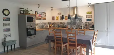 a kitchen with a table with chairs and a stove at LA PETITE BICOQUE au fond du jardin in Quillan