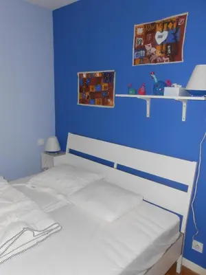 a blue bedroom with a white bed and a blue wall at Superbe villa 4 ch climatisées avec piscine privée in Roquetaillade