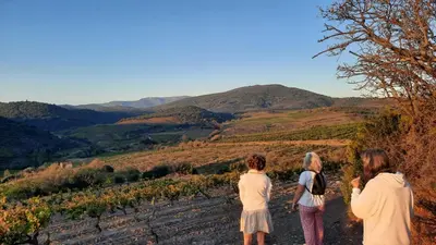 three women standing on a dirt road looking at the mountains at La Barbacane de Cascastel-des-Corbières in Cascastel-des-Corbières