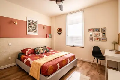 a bedroom with a bed and a window and a desk at Appart BonaVita Narbona in Narbonne