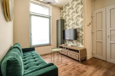 a living room with a green couch and a table at Appart BonaVita Narbona in Narbonne