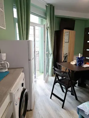 a kitchen with a table and a refrigerator and a table and chairs at Galamus Bonheur - L'art de choisir in Saint-Paul-de-Fenouillet