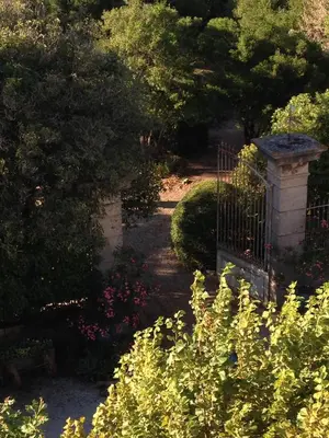 a garden with a gate and some bushes and flowers at Chambre Art Déco in Moux