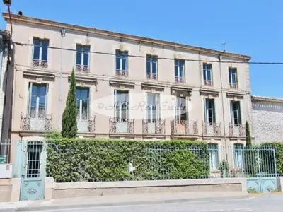 a large building with a fence in front of it at Chambre Art Déco in Moux