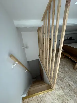 a wooden staircase in a room with a bed at Joli appartement en ville in Revel