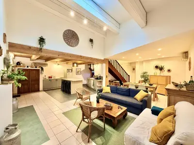 a large kitchen with wooden ceilings and a wooden door at La maison de Lalie in Lagrasse