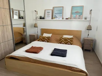 a bedroom with a bed with two towels on it at Maison quartier la Campane Narbonne in Narbonne