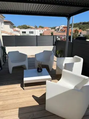 a group of white chairs and a table on a patio at Maison quartier la Campane Narbonne in Narbonne