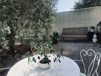 a table with a potted plant on top of it next to a bench at Studio Peyresol in Villasavary