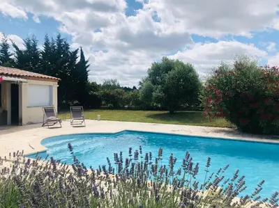 a swimming pool with two chairs in a yard at Studio Peyresol in Villasavary