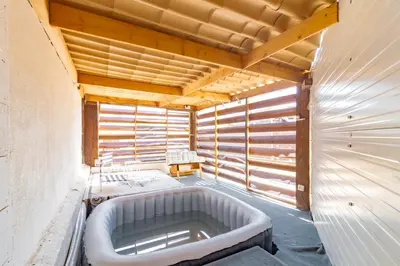a large bath tub in a room with wooden walls at Ohm Sweet Home - Maison climatisée in Carcassonne