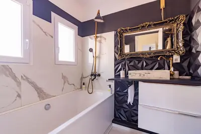 a bathroom with a mirror and a bath tub at Ohm Sweet Home - Maison climatisée in Carcassonne