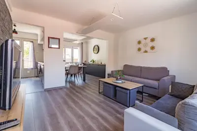 a living room with a couch and a table at Ohm Sweet Home - Maison climatisée in Carcassonne