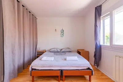 a bedroom with a bed and a window at Ohm Sweet Home - Maison climatisée in Carcassonne