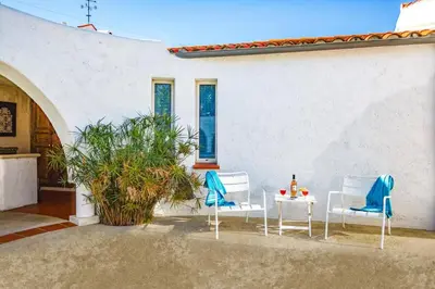 a patio with two chairs and a table at Villa Les Arches by Villa Plus in Villedaigne
