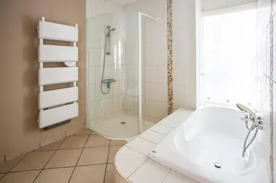 a bathroom with a shower and a white tub at Villa Les Arches by Villa Plus in Villedaigne