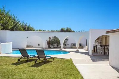 a patio with two chairs and a swimming pool at Villa Les Arches by Villa Plus in Villedaigne