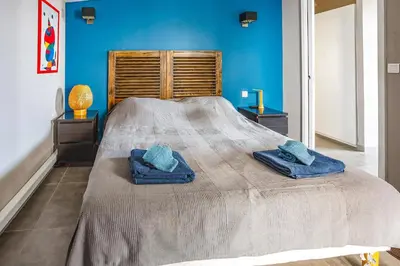 a bedroom with a large bed with blue walls at Villa Saffron by Villa Plus in Villedaigne