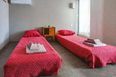 two beds in a room with red sheets and towels at Villa Saffron by Villa Plus in Villedaigne