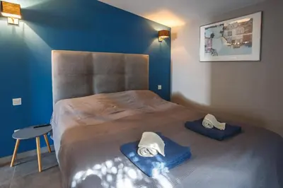 a bedroom with a large bed with blue walls at Villa Saffron by Villa Plus in Villedaigne