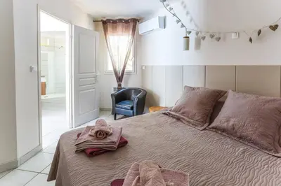 a bedroom with a bed with a robe on it at Villa Le Petit Nid by Villa Plus in Villedaigne