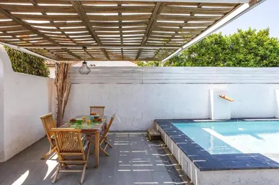 a patio with a table and a swimming pool at Villa Le Petit Nid by Villa Plus in Villedaigne