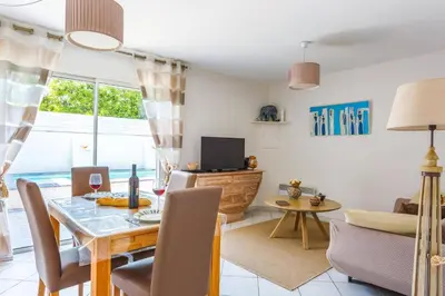 a living room with a dining table and a tv at Villa Le Petit Nid by Villa Plus in Villedaigne