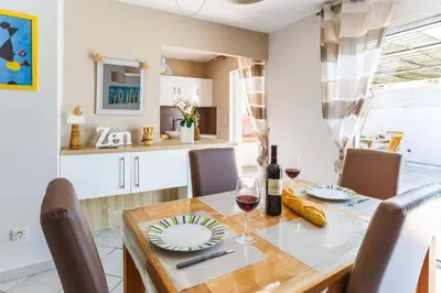 a dining room and kitchen with a wooden table and chairs at Villa Le Petit Nid by Villa Plus in Villedaigne