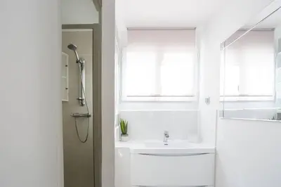 a white bathroom with a sink and a window at Villa de lOrmeau by Villa Plus in Cambieure