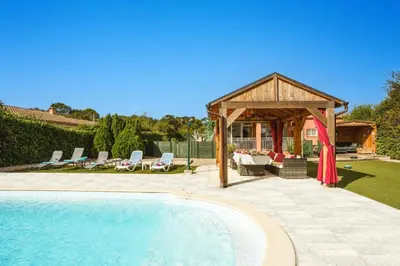 a swimming pool with a gazebo next to a house at Villa de lOrmeau by Villa Plus in Cambieure