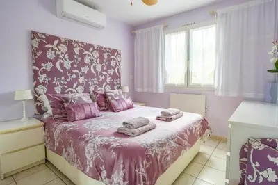 a bedroom with a pink bed with towels on it at Villa de lOrmeau by Villa Plus in Cambieure