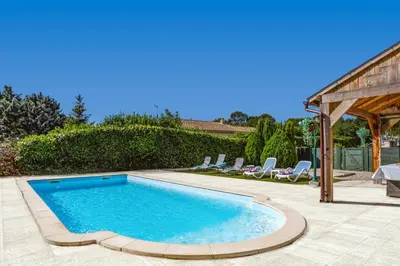 a swimming pool in a yard with chairs around it at Villa de lOrmeau by Villa Plus in Cambieure