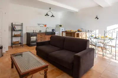 a living room with a couch and a kitchen at Villa Les Juliannes by Villa Plus in Azillanet