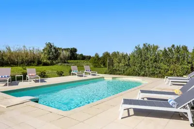 a swimming pool with chaise lounge chairs and a swimming pool at Villa Les Juliannes by Villa Plus in Azillanet