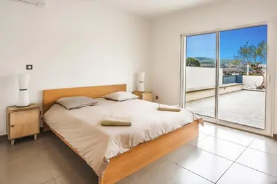 a bedroom with a large bed and a balcony at Villa Terre des Vins by Villa Plus in Portel-des-Corbières