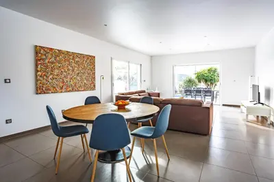 a living room with a table and chairs and a couch at Villa Terre des Vins by Villa Plus in Portel-des-Corbières