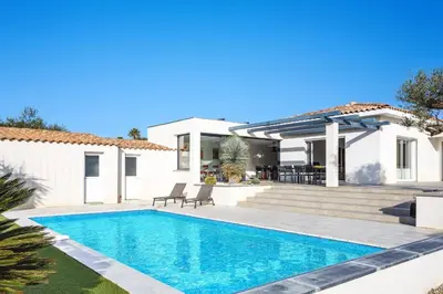 a villa with a swimming pool in front of a house at Villa Terre des Vins by Villa Plus in Portel-des-Corbières