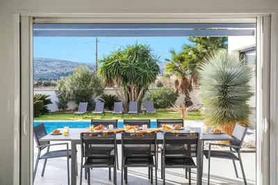 a dining room with a table and chairs at Villa Terre des Vins by Villa Plus in Portel-des-Corbières