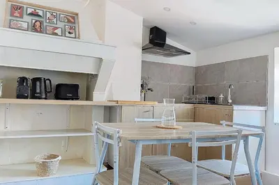 a kitchen with a wooden table and two chairs at Le Pradel in Carcassonne
