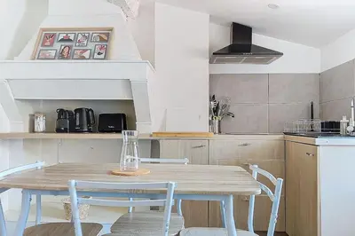 a white bedroom with a bed and a fireplace at Le Pradel in Carcassonne