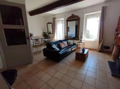 a living room with a couch and a table at Vue de rêve sur lagune de mer in Bages