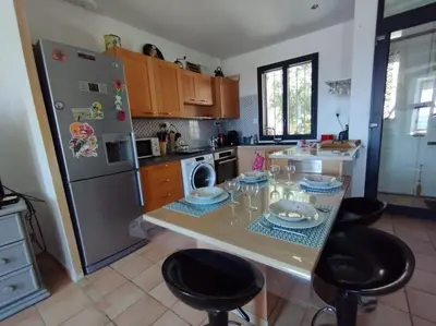 a kitchen with a table with chairs and a refrigerator at Vue de rêve sur lagune de mer in Bages